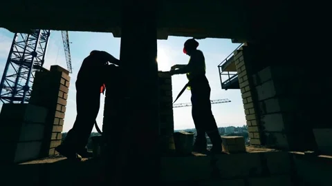 Silhouettes of Labor: Workers on a Construction Site at Dusk Stock Footage 270495282