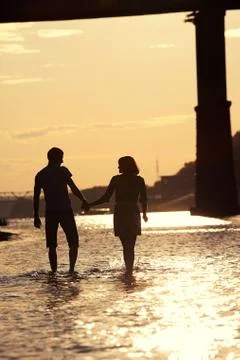 Silhouettes of lovers at sunset Stock Photos