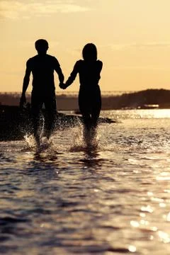 Silhouettes of lovers at sunset Stock Photos