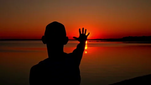 Silhouettes of a Man with Raised Hands at Sunset Alone Vídeo Stock 252798567