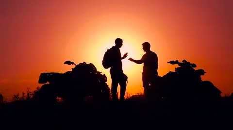 Silhouettes of men and ATVs at sunset. Men shake hands Stock Footage 67548287