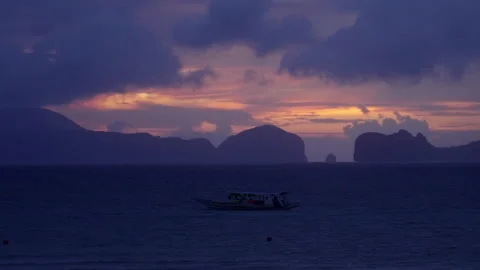 Silhouettes of mountains at sunset in the ocean Stock Footage 281474425