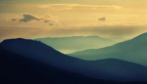 Silhouettes of the mountains at sunset Stock Photos