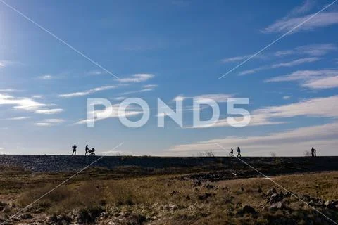 Silhouettes of people in front of blue sky Stock Photos