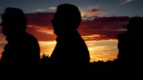 Silhouettes of people passing by walking at Cordoba bridge at dusk sunset Stock Footage 45160053