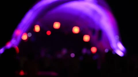 Silhouettes of People Raise Hands in Front of Bright Colorful Strobing Lights 库存影片 241885042
