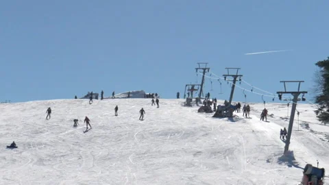 Silhouettes of people skiing downhill in a mountain ski resort Stock Footage 229373003