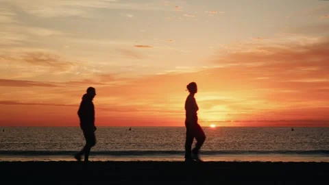 Silhouettes of a persons walking at sunset Stock Footage 297766737