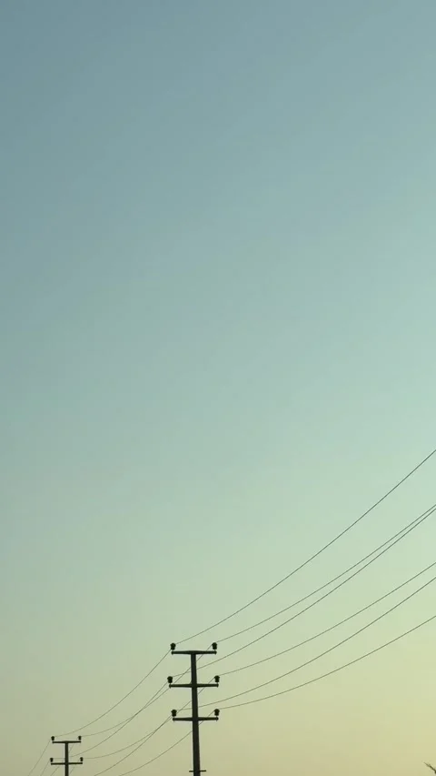 Silhouettes of Power Lines at Sunset with a Gradient Sky Stock Footage 314276542