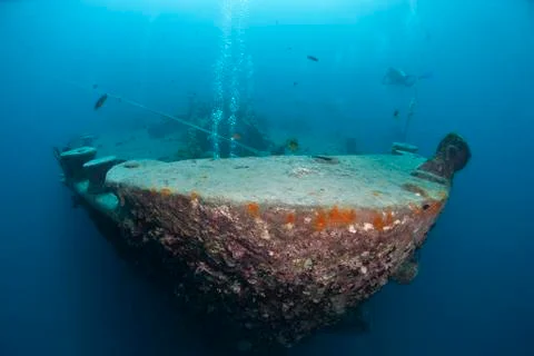 Silhouettes of scuba divers exploring the bow of a shipwreck. red sea, egypt. Stock Photos