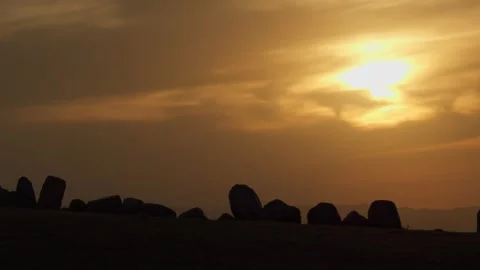 Silhouettes of stones at sunset with dramatic sun rays Stock Footage 333953036
