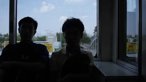 Silhouettes of two boys on a train as it passes outside of Tokyo Vídeo Stock 92199091