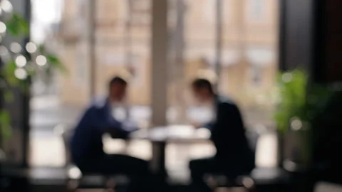 Silhouettes of two men working together at the table in office near window. Vídeos de archivo 88573178