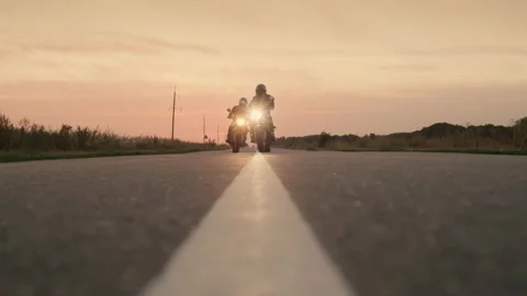 Silhouettes of two motorcyclists quickly pass by the camera on the highway Stock Footage 139001400