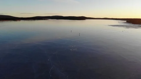 Silhouettes of two persons ice skating in the sunset on a frozen lake Stock Footage 111667758