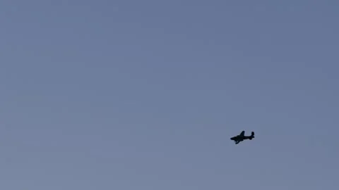 Silhouettes of two propeller planes flying in formation against a blue sky Stock Footage 340938792