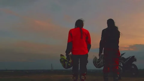 Silhouettes two riders with their bikes on the background of beautiful sunset.  Stock Footage 108727492