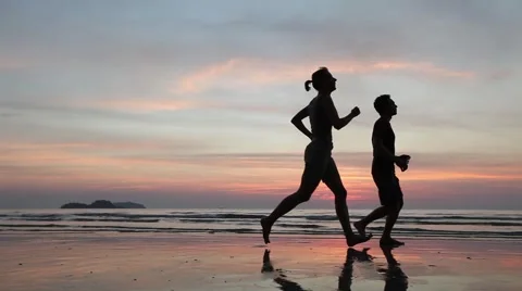 Silhouettes of two runners on the beach Stock Footage 59738528