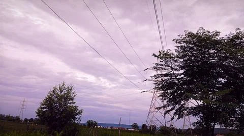 Silhouettes Under Cloudy Sky with Power Lines 스톡 사진