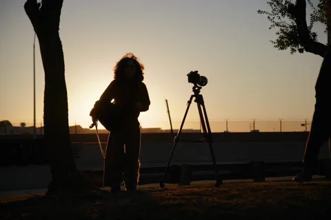 Silhouettes of Videographers at Sunset with Tripod Setup Stock Footage 297901005