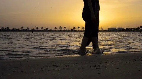 Silhouettes walking on the beach in sunset Stock Footage 72585509