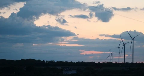 Silhouettes of wind power plants generating energy in field Stock Footage 113602174