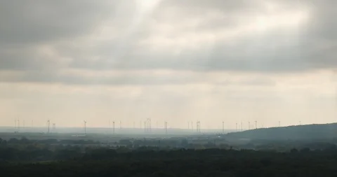 Silhouettes of wind turbines under moving sun rays Stock Footage 118167964