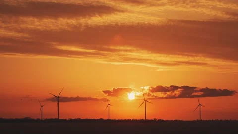 Silhouettes of windmills producing electricity at sunset Stock Footage 155689111