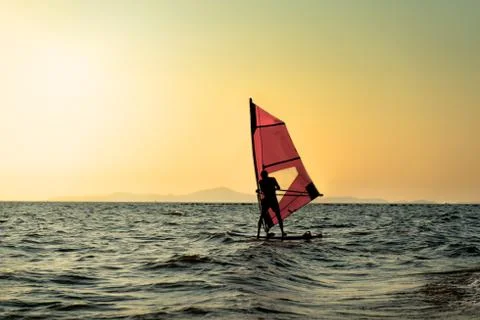 Silhouettes of  windsurfers at the sunset Stock Photos
