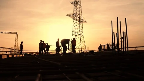 Silhouettes of workers on a construction site at sunset. Stock Footage