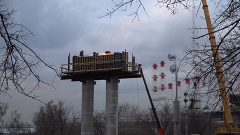 Silhouettes of workers-installers  working on a column, a support for an auto Stock Footage 126056554