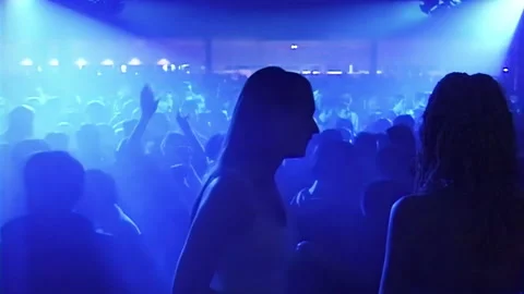 Silhouettes of young people dancing in front of a laser show background in th Stockbeeldmateriaal 169776888