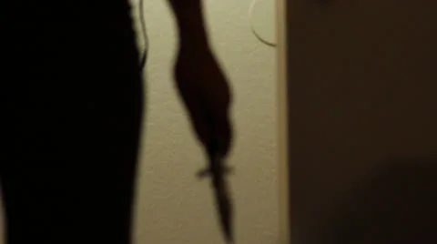 Silhoutte of female killer with knife walks towards camera Stock Footage