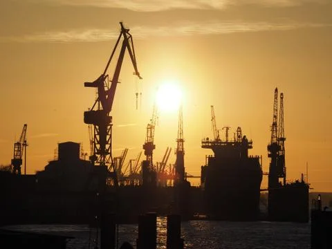 Silhoutte harbour with cranes in sunset light Stock Photos