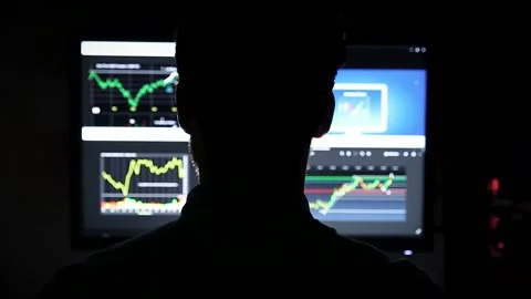 A silhoutte of a man in front of a screen looking at stock market index charts Stock Footage 142842469
