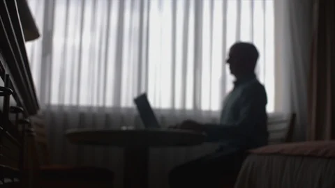 Silhoutte man, works on computer in hotel room. Stock Footage 90398875