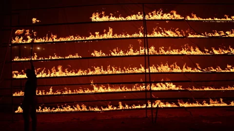 Silhouttes at Row of flames Stock Footage 324520120