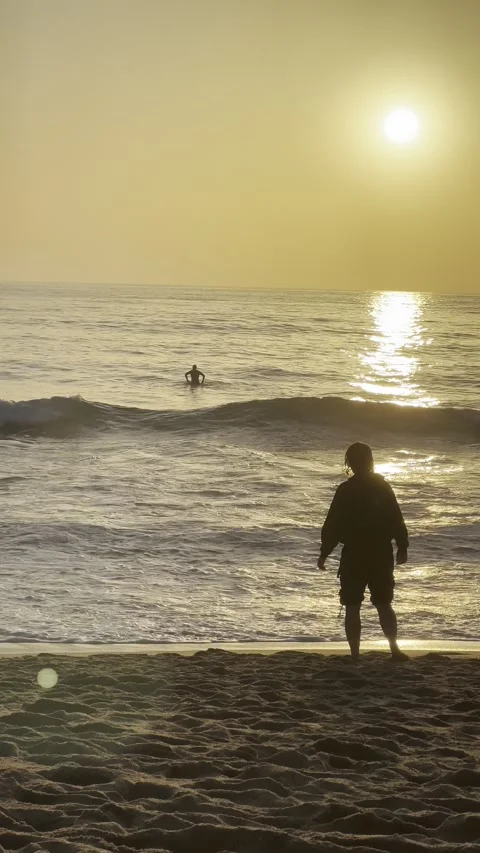 A silhuete of a person getting ready to step into the cold water in Ericeira Stock Footage 304882887