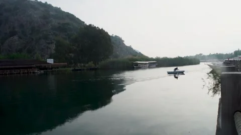 SILICATE OF TWO YOUNG PEOPLE CROSSING THE BOAT, CALM WATER AND GREEN VIEW Stock Footage 242527016