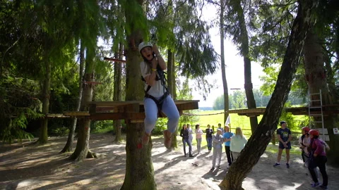 SILICHY, BELARUS - 2, AUGUST, 2019: A girl on a cable descends from a tree. Rope Stock Footage 129952253