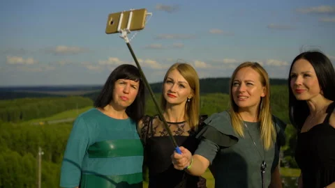 SILICHY, BELARUS - 2, AUGUST, 2019: Girls take selfies on a background of green Stock Footage 129956427