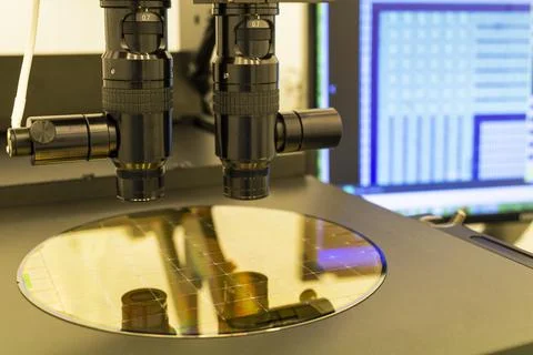 Silicon wafer on machine process examining in microscope. Stock Photos
