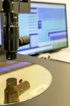 Silicon wafer on machine process examining in microscope. Stock Photos