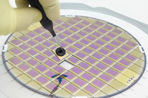 Silicon wafer with microchips, fixed in a holder with a steel frame on a gray Stock Photos