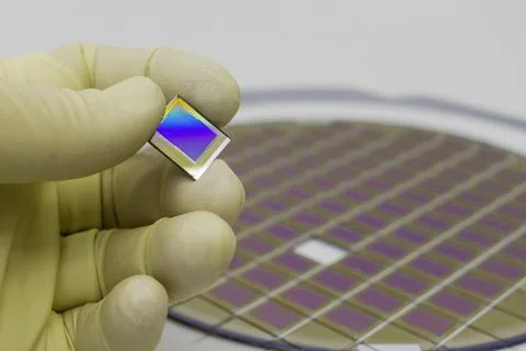 Silicon wafer with microchips, fixed in a holder with a steel frame on a gray Stock Photos