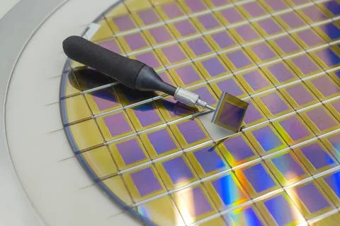 Silicon wafer with microchips, fixed in a holder with a steel frame on a gray Stock Photos