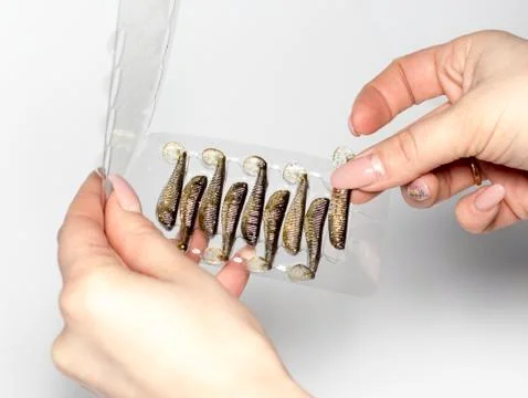 Silicone baits in female hands Stock Photos