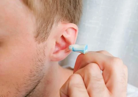 Silicone earplug next to the ear. Insert ear protection Stock Photos