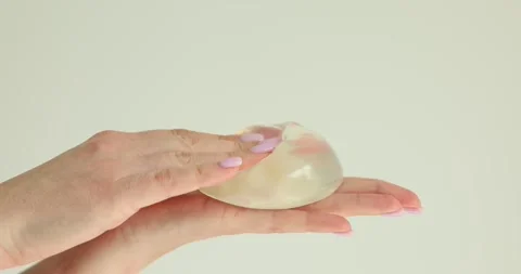 Silicone implants in hands of plastic surgeon concept Stock Footage 240422618