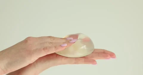 Silicone implants in hands of plastic surgeon concept Stock Footage 285538242